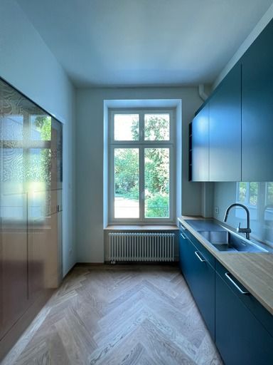 Eine Küche mit blauen Schränken und einem großen Fenster