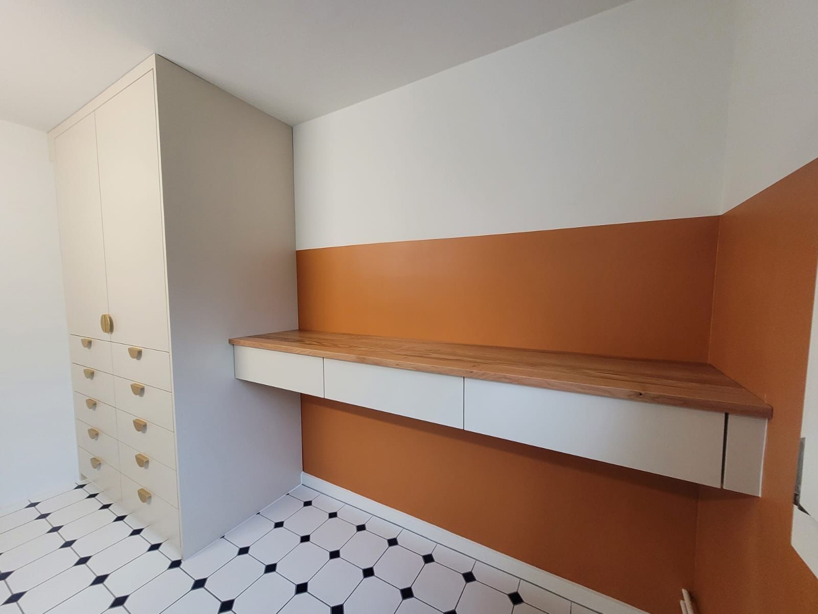 In der ecke des zimmers steht ein schreibtisch.