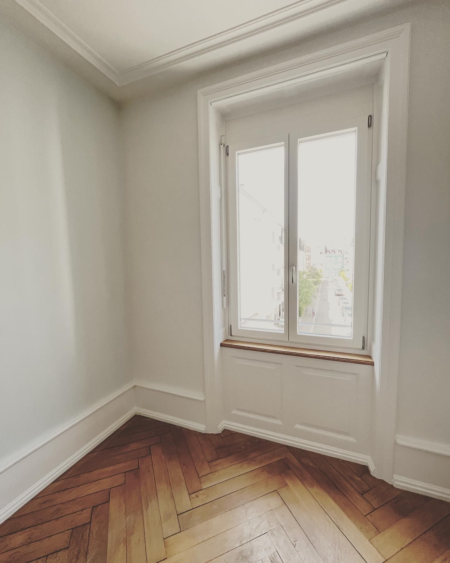 Ein leerer Raum mit einem Fenster und einem Holzboden