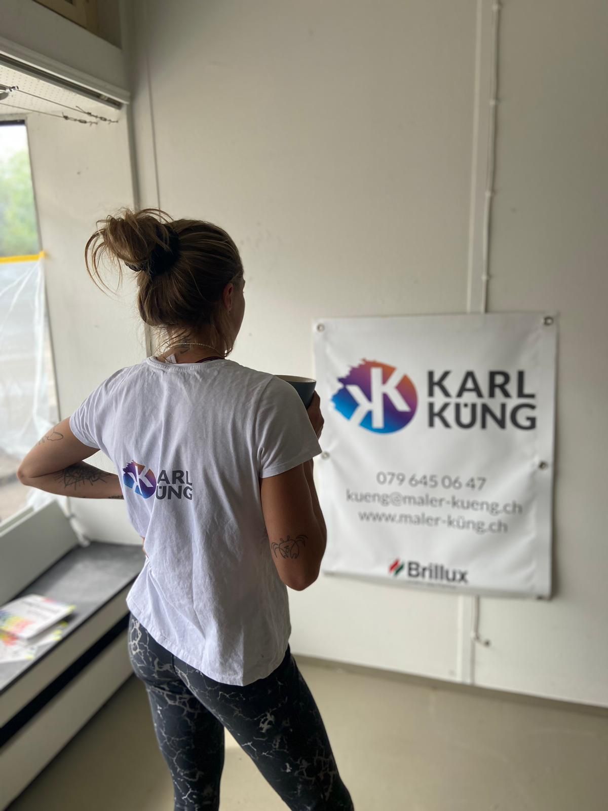 Eine Frau steht vor einem Karl Kung Schild