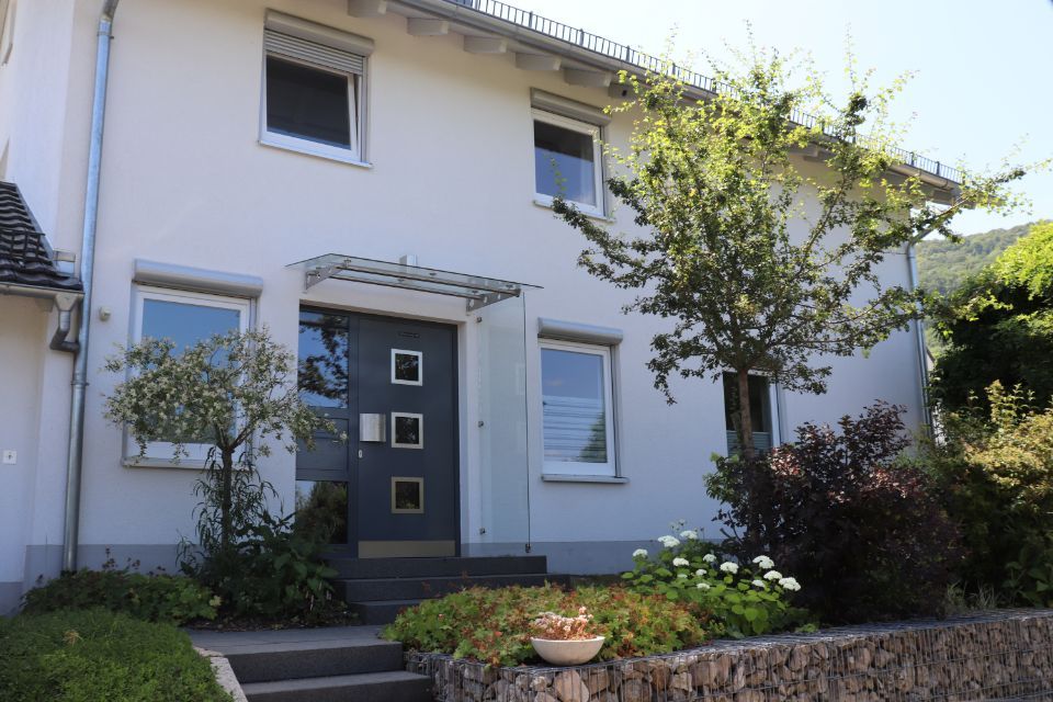 weiße Fassade, graue Tür beim Einfamilienhaus