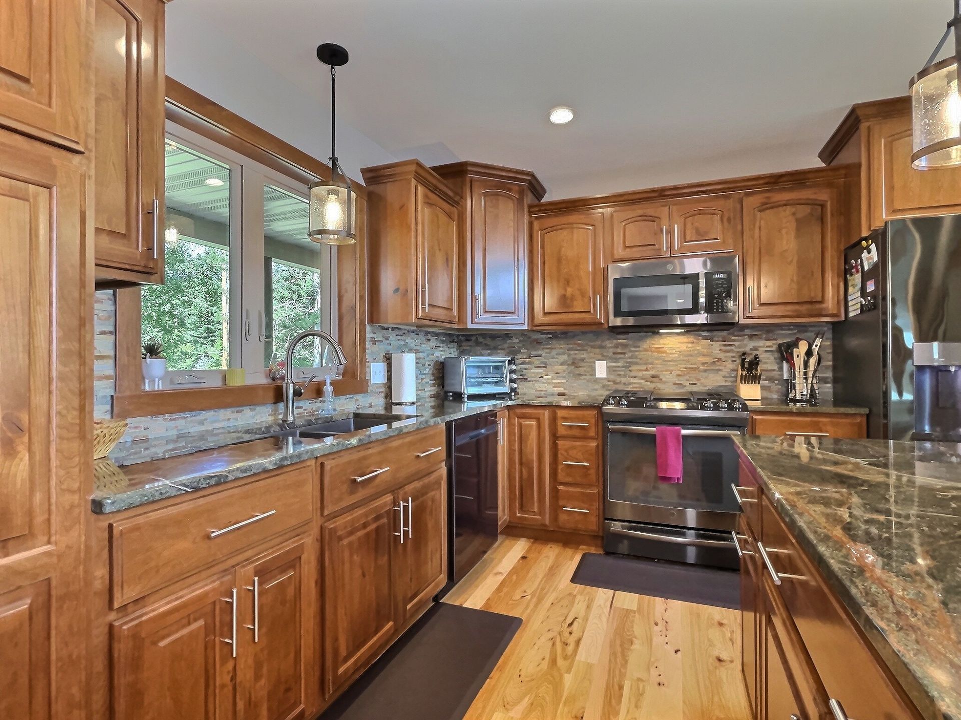 Kitchen with wooden cabinets, stainless steel appliances, and granite countertops.
