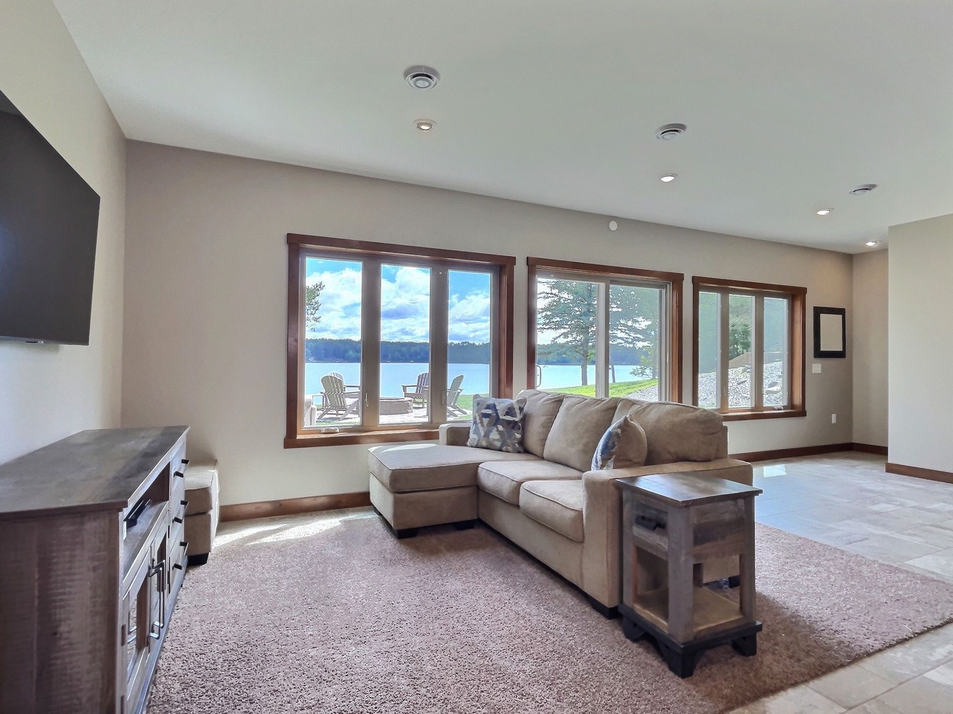 Living room with sectional sofa, lake view windows, and television.