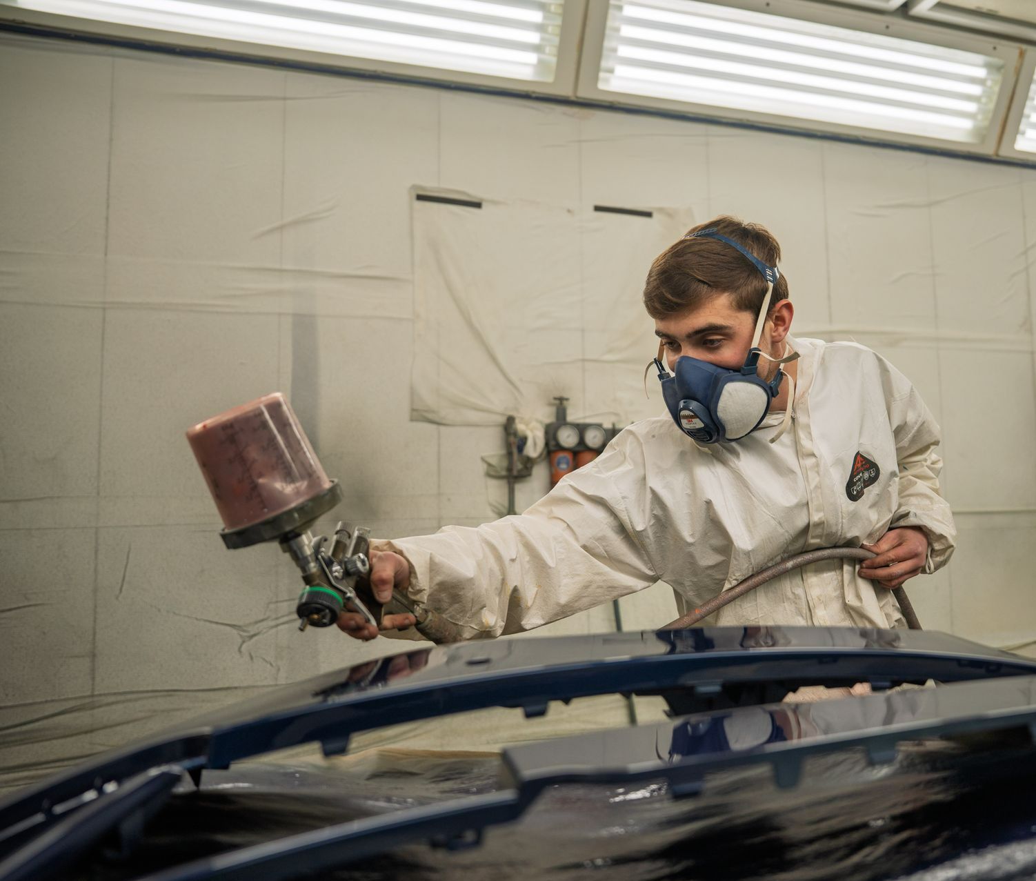 Mécanicien réalisant les retouches de peinture sur une carrosserie