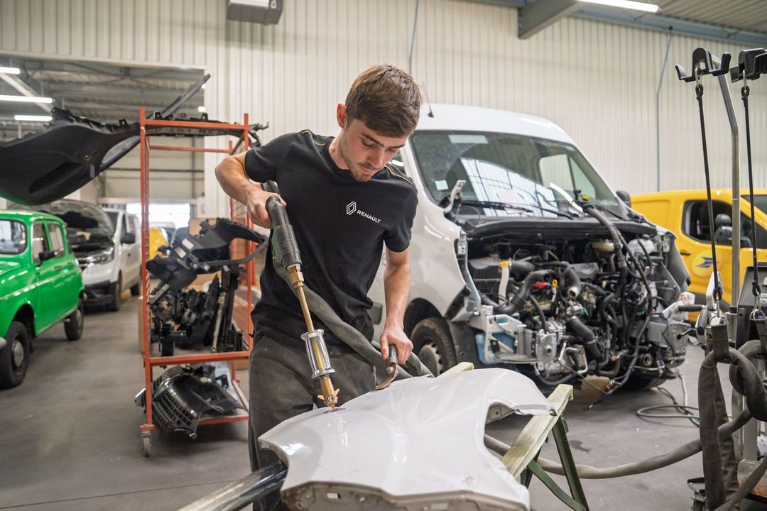 Carrossier intervenant sur la carrosserie d'une voiture