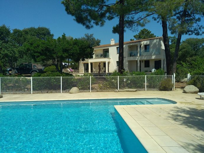 Maison avec piscine en premier plan.
