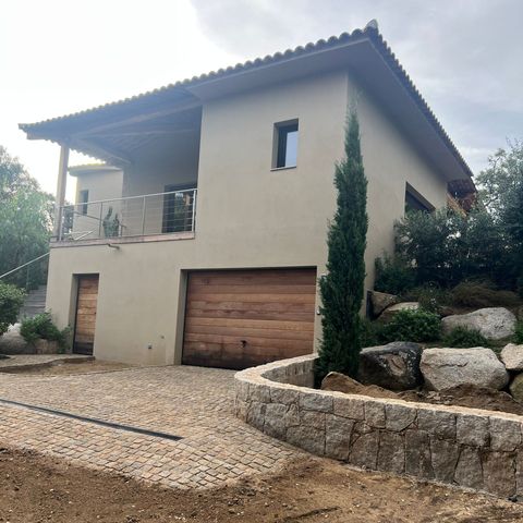 Maison avec balcon et porte de garage.