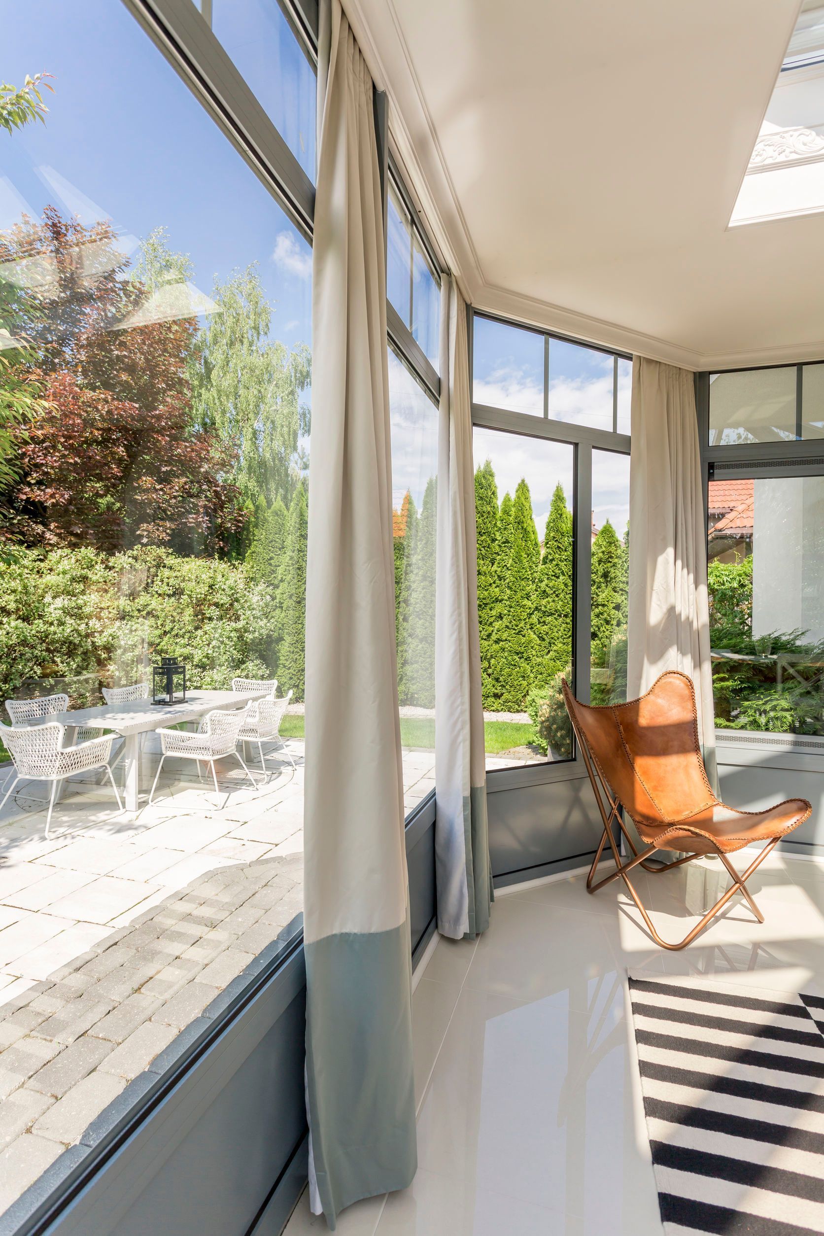 Una sala de estar con una gran ventana y una silla delante de ella.