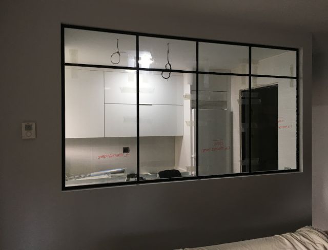 Hay una ventana grande en la pared entre la sala de estar y la cocina.