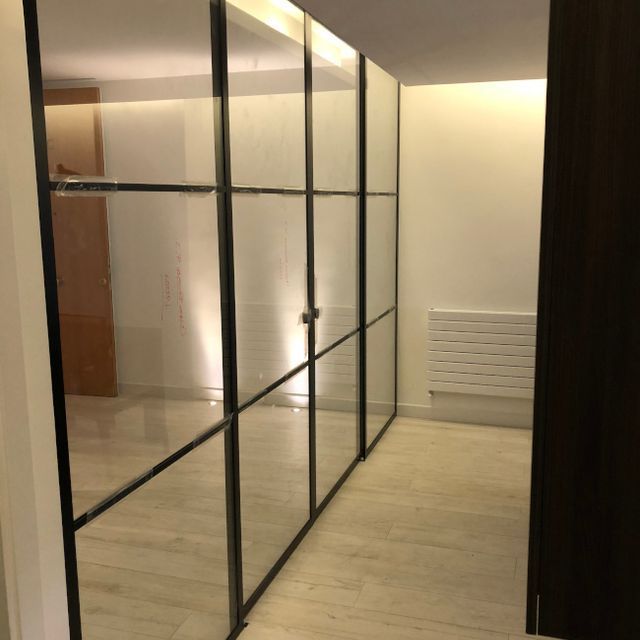 Un pasillo con paredes de espejo y un radiador.