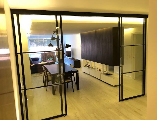 Una sala de estar con una mesa y sillas y una puerta corrediza de vidrio.