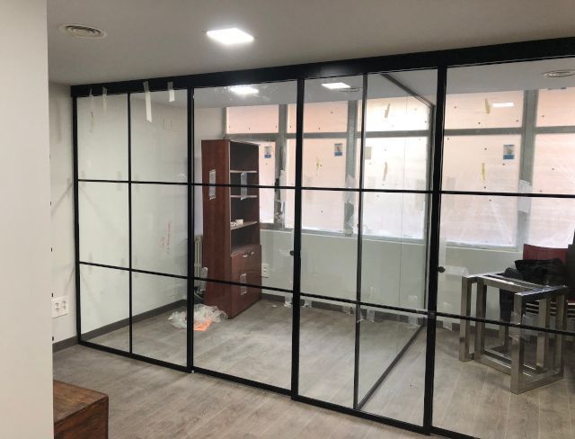 Una habitación con muchas ventanas y puertas corredizas de vidrio.