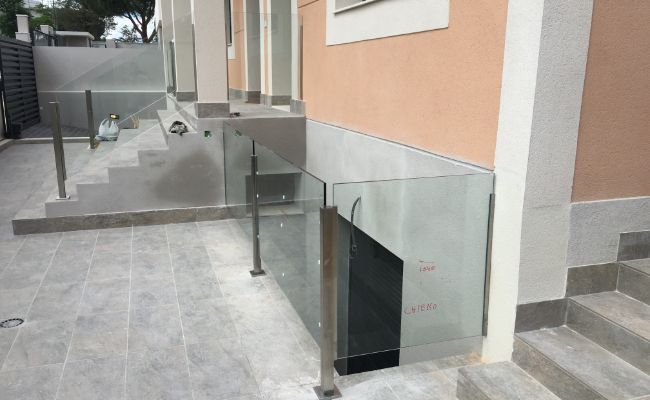 Un edificio con escaleras y una barandilla de vidrio en el costado.