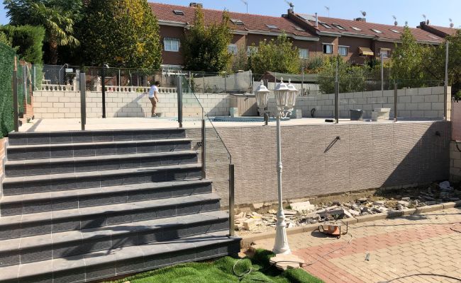 Una escalera que conduce a una piscina en un patio trasero.