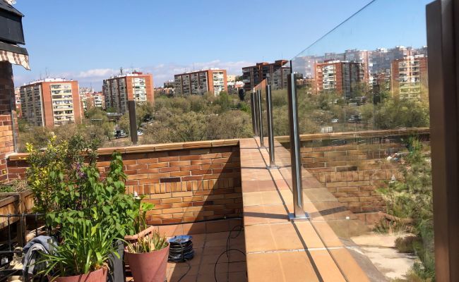 Un balcón con plantas en macetas y vista a una ciudad.