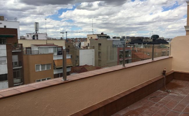 Un balcón con vista a una ciudad con edificios al fondo.