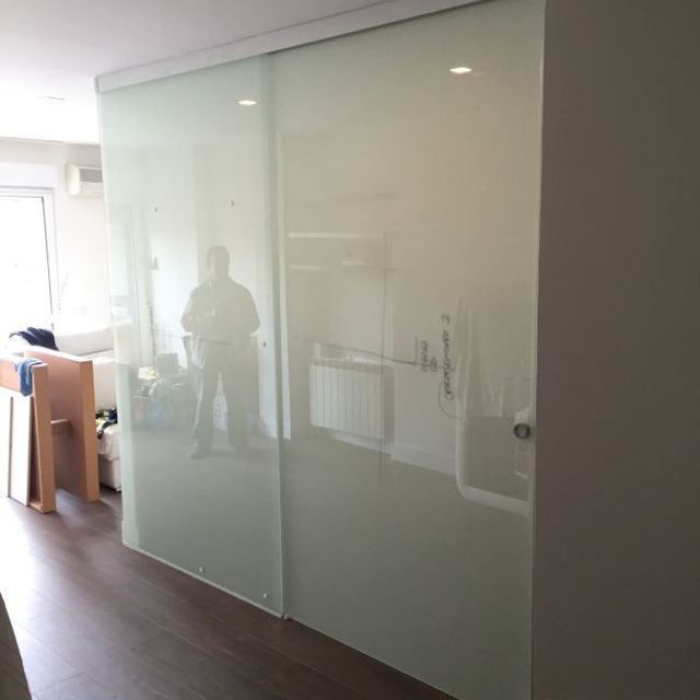 Un hombre está de pie en una habitación con puertas corredizas de vidrio.