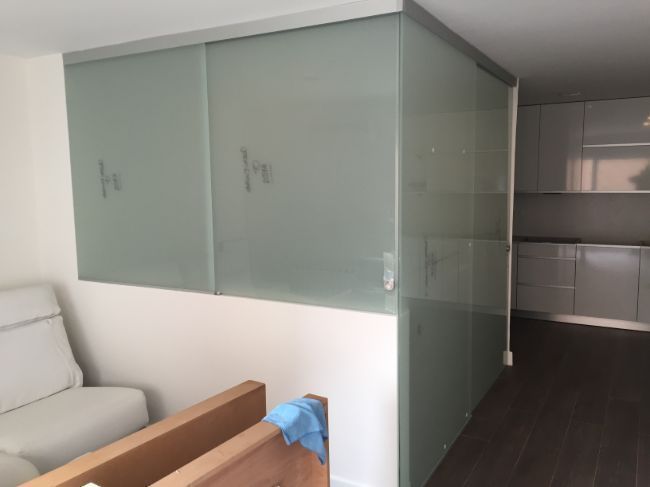 Una sala de estar con un sofá y puertas corredizas de vidrio.