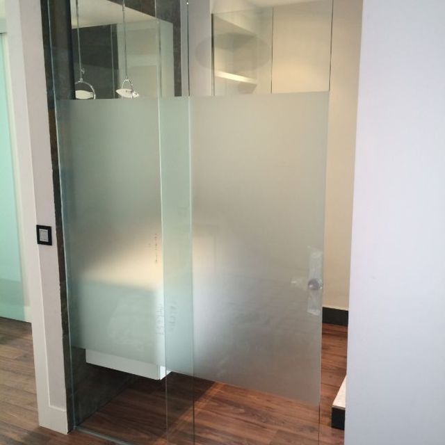 Una puerta corrediza de vidrio con una película de vidrio esmerilado.