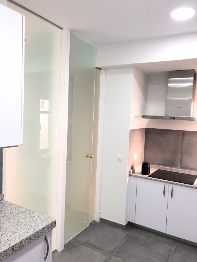 Una cocina con gabinetes blancos y un horno de estufa.