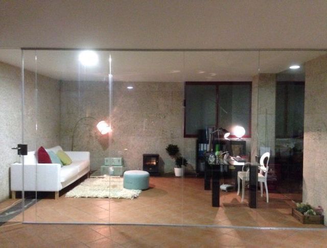 Una sala de estar con una pared de cristal y un sofá.