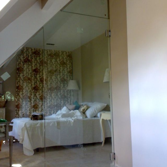 Un dormitorio con una cama detrás de una pared de cristal.