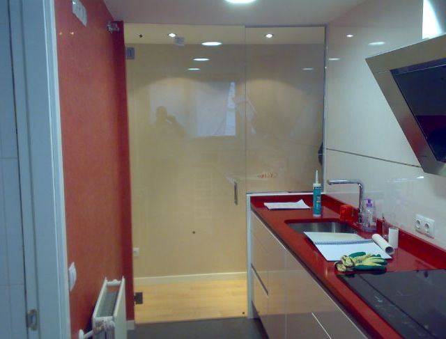 Una cocina con encimeras rojas y gabinetes blancos.