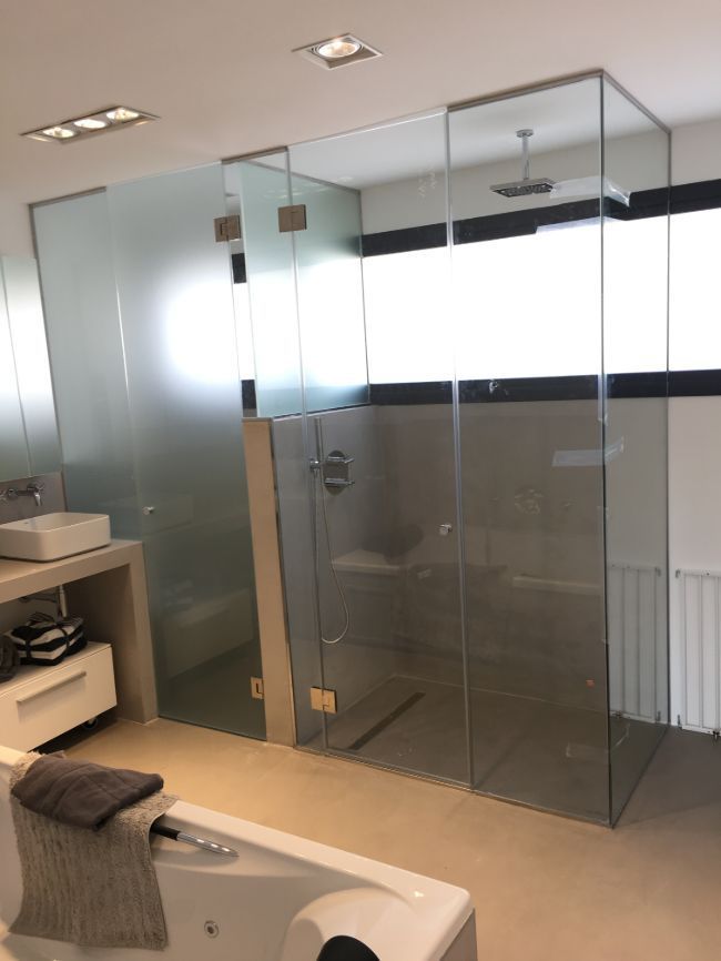 Un baño con ducha a ras de suelo y bañera.