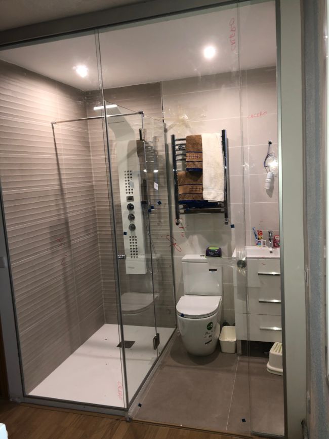 Un baño con inodoro, lavabo y ducha.