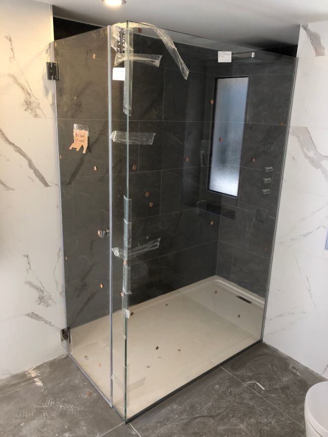 Un baño con ducha a ras de suelo y un inodoro.