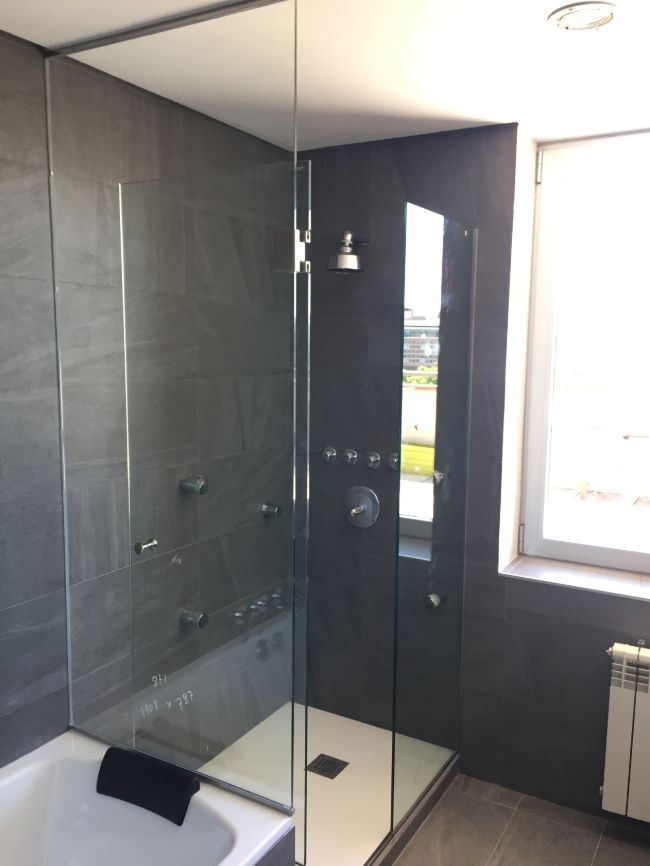 Un baño con bañera y ducha a ras de suelo.