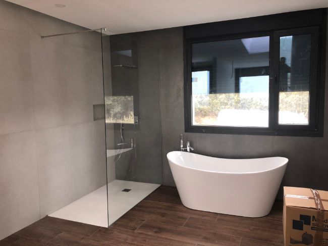 Un baño con bañera y ducha a ras de suelo.