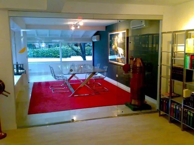 Un comedor con mesa y sillas y una alfombra roja.