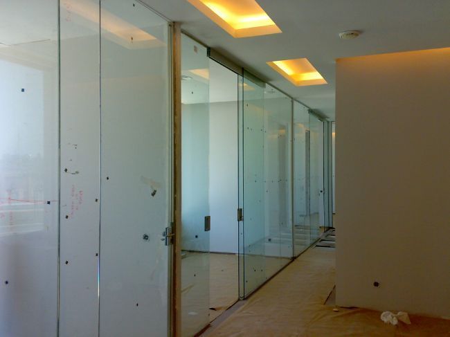 Un largo pasillo con muchas puertas de vidrio.