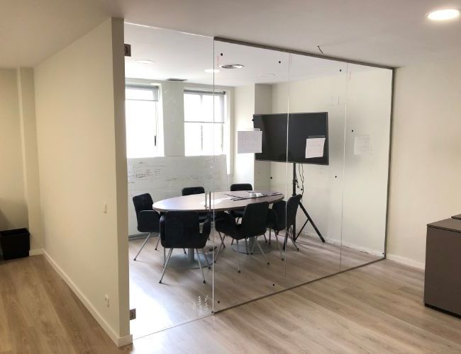 Una sala de conferencias con una mesa redonda y sillas