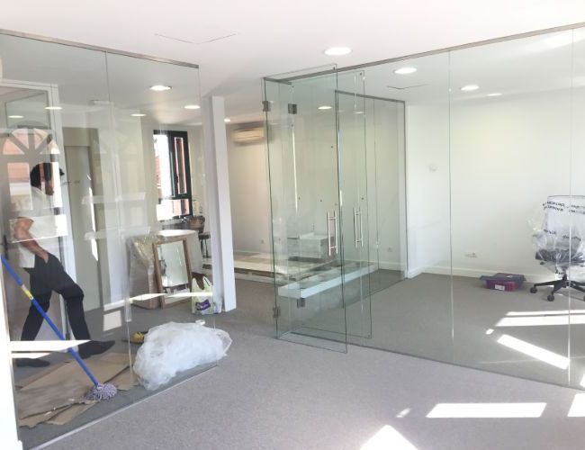 Un hombre está limpiando una habitación con puertas corredizas de vidrio.