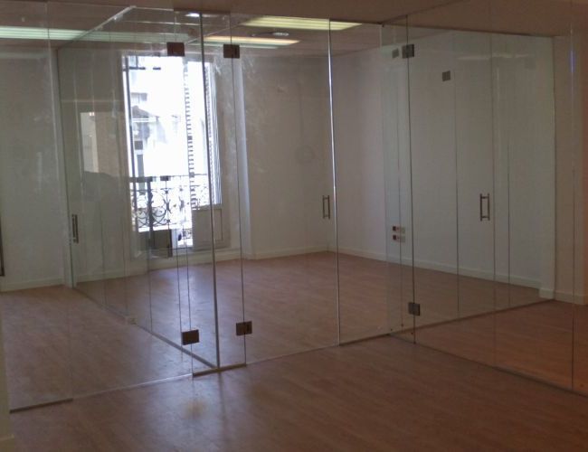 Una habitación vacía con muchas puertas de vidrio