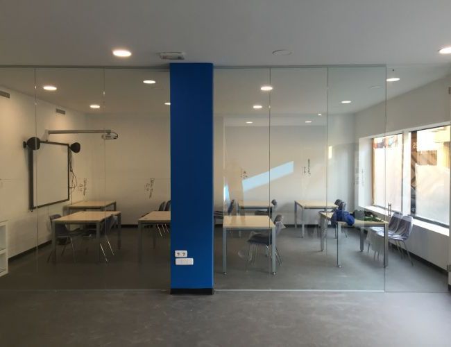 Una habitación con mesas y sillas y un pilar azul.