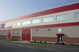 Un gran edificio rojo y blanco con un reloj en el costado.