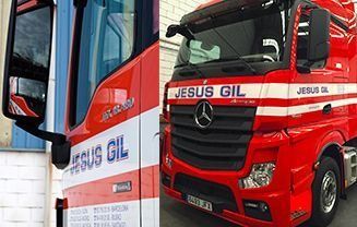 Un camión rojo y blanco está estacionado frente a un edificio.