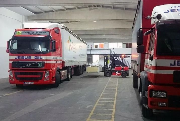 Un camión rojo y blanco con la palabra Jesús Oil en el frente.