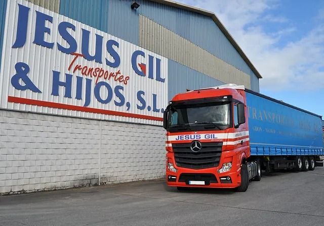 Un camión está estacionado frente a un edificio que dice Jesús Gil & Hijos SL