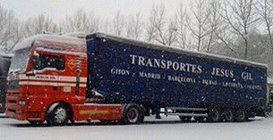 Un camión semirremolque rojo y azul está estacionado en la nieve.