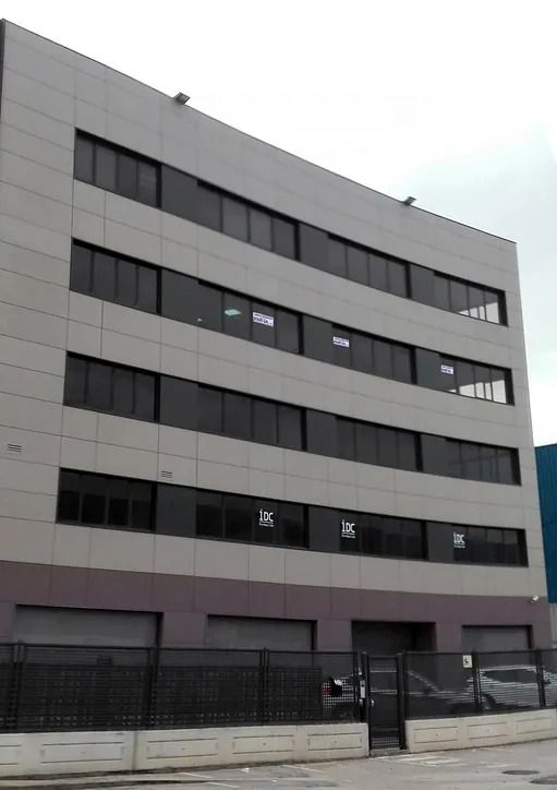Un edificio con muchas ventanas y una valla alrededor.