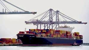 Un gran barco portacontenedores está atracado en un puerto.