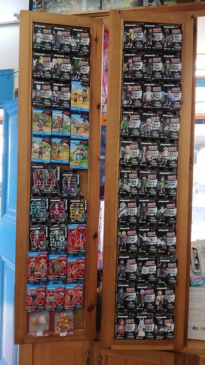 Estantes llenos de varias cajas de juguetes en un entorno de tienda.