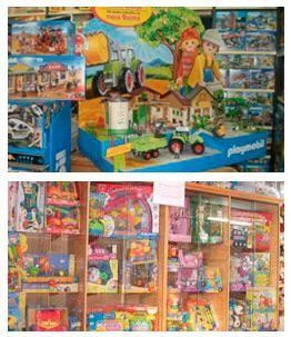 Exhibición de tienda de juguetes con juegos de granja Playmobil y otros juguetes coloridos.