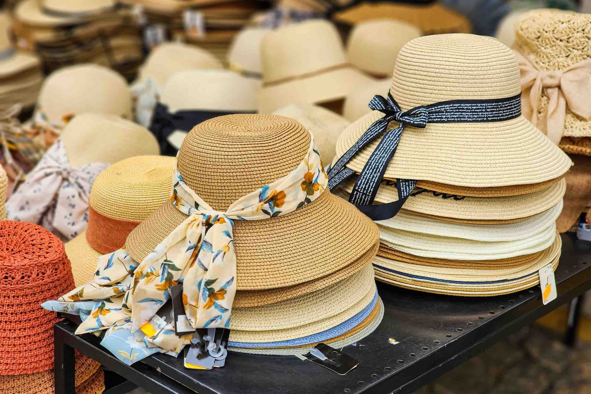 Un montón de sombreros de paja están apilados uno encima del otro sobre una mesa.