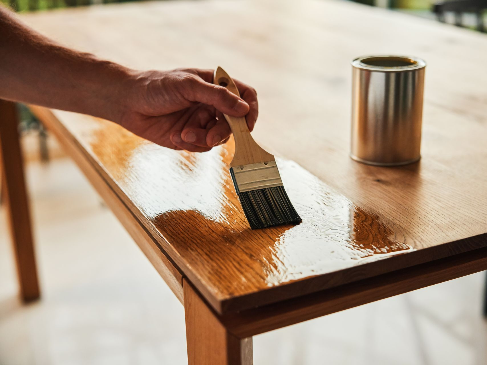Application de vernis sur une table en bois