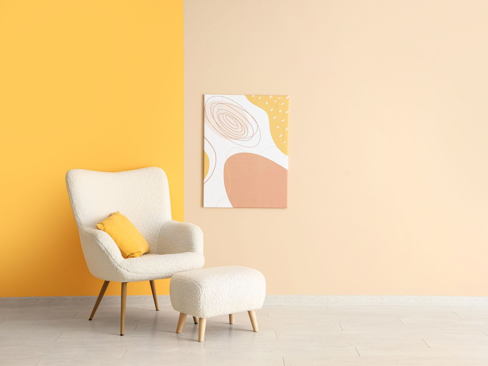 Salon avec fauteuil, mur avec peintures jaunes et crème